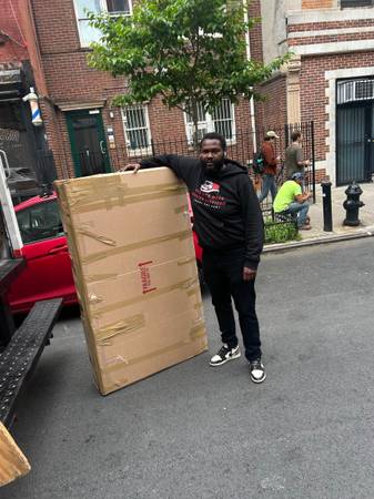 Mover handling a large package on a Brooklyn street