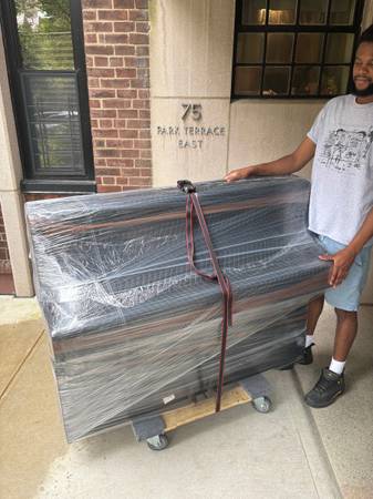 Carefully wrapped furniture being moved on a dolly